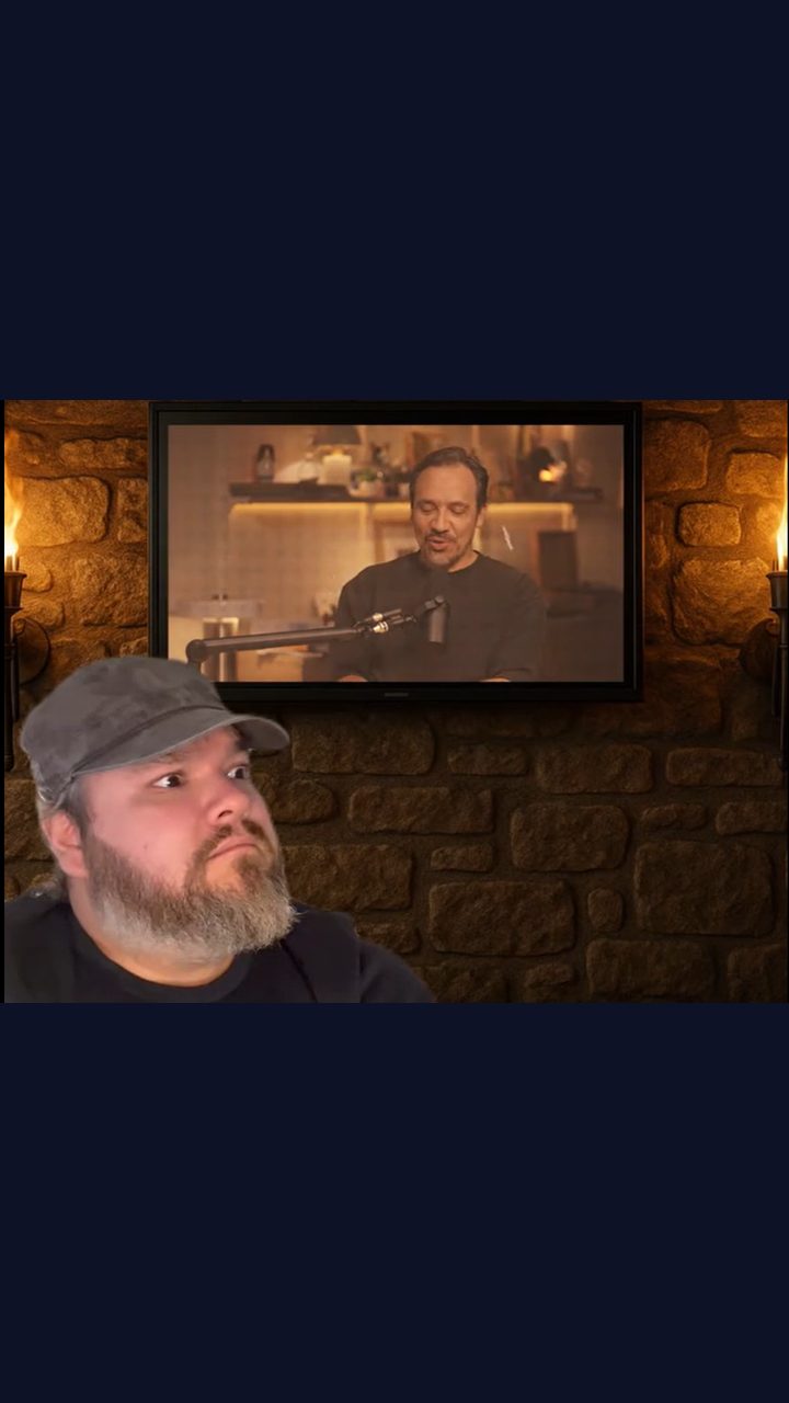 Image de la vidéo : un homme réagit, face à un écran mural qui diffuse une interview.